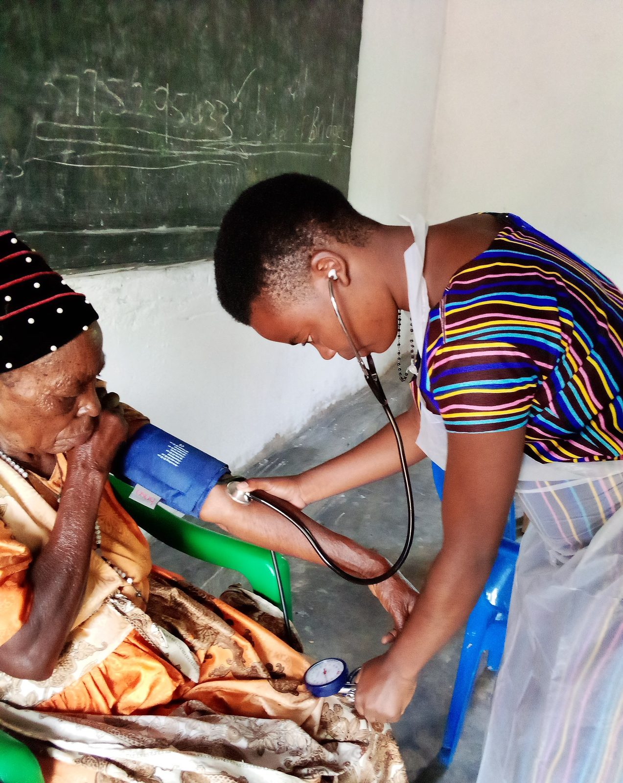 Nurse attending to a patient at the bedside.
